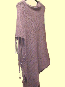 Knitted long poncho with beaded fringe.